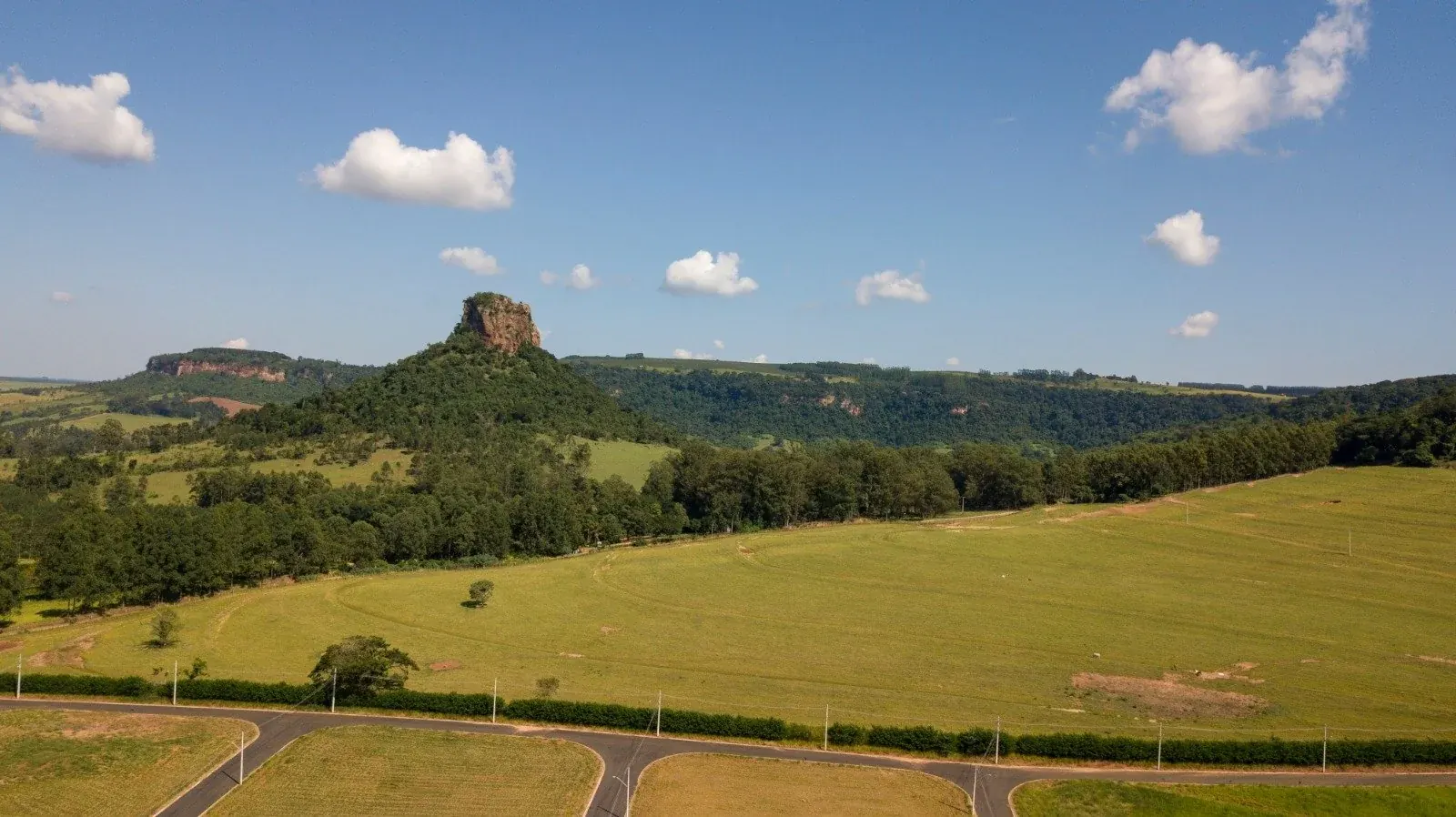Paisagem verde de Analândia com formação rochosa ao fundo